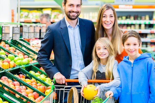 A family shops in a supermarket produce aisle