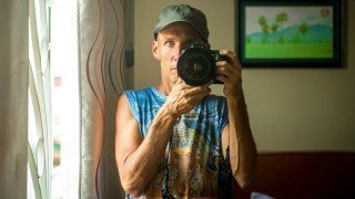 Mark Tassi photographs himself in a mirror in Cambodia