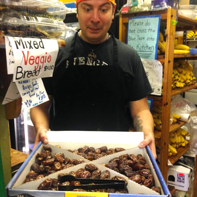Phil looks with delight at dates in a large box at Arnold's Way