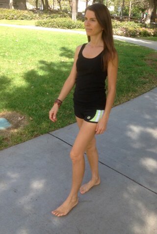 Alicia Grant walks barefoot along a sidewalk