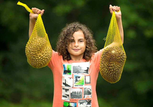Cappi Osborne raises high two durians at The Woodstock Fruit Festival in 2014