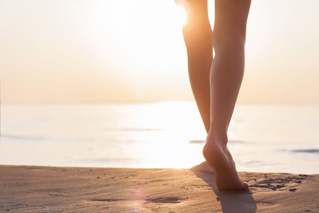 A woman walks on a beach