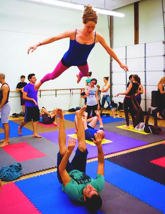 Brittany Taylor performs a flying pop while practicing acroyoga