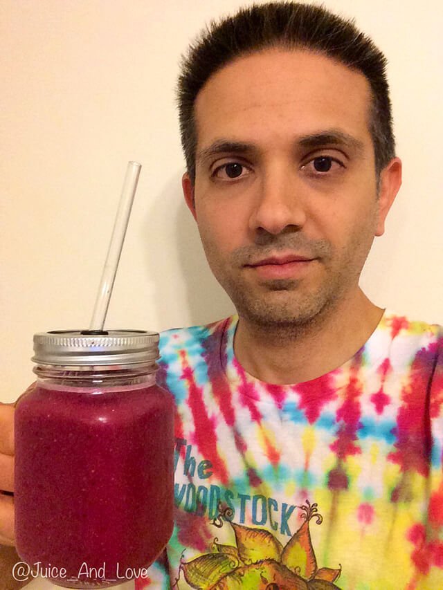 John Fallucca raises a purple juice in a mason jar