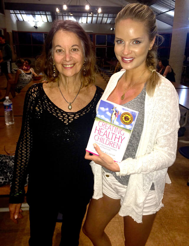 Karen Ranzi with an attendee holding Creative Healthy Children at The Woodstock Fruit Festival Hawaii