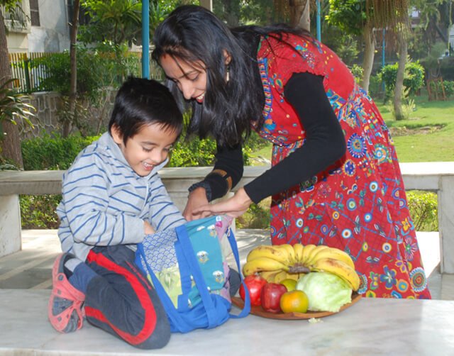 Anjali and Manikya Sanghi pack bags with fruit