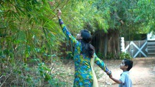 Anjali and Manikya Sanghi reach for flowers outside their home