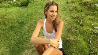 Kat Green sitting on a hilly field