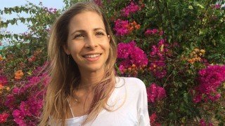 Kat Green smiles in front of a tree