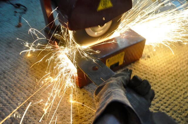 Korey Constable sharpens a lawnmower blade