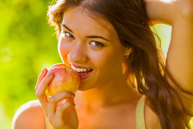 Woman enjoys an apple outside