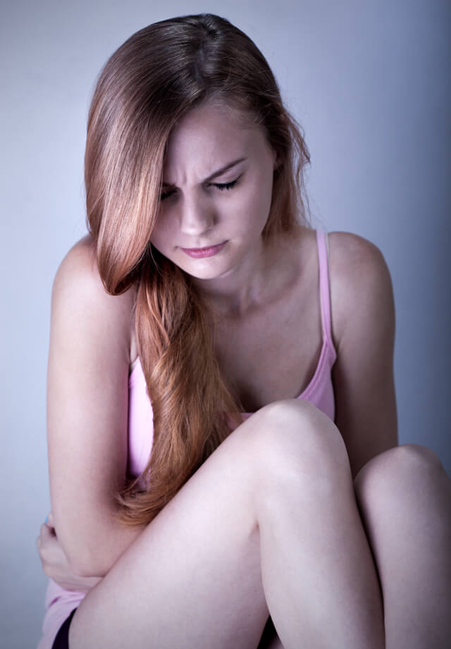 Portrait photograph of a young woman suffering from abdominal pain