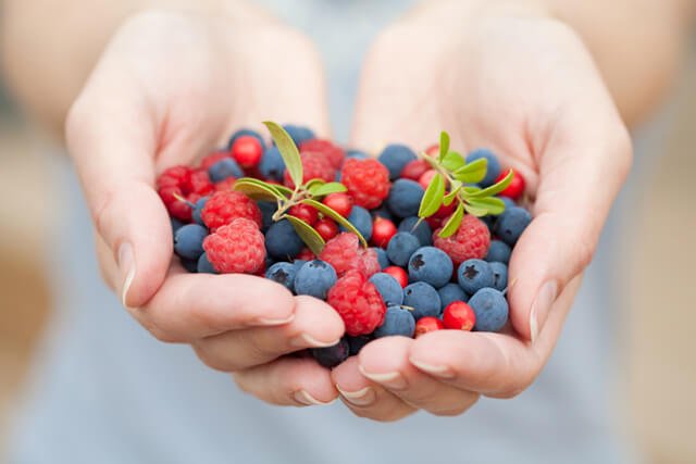 A woman holds fresh berries