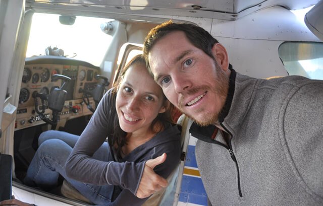 Korey Constable poses with Deanna Husk, seated in a cockpit