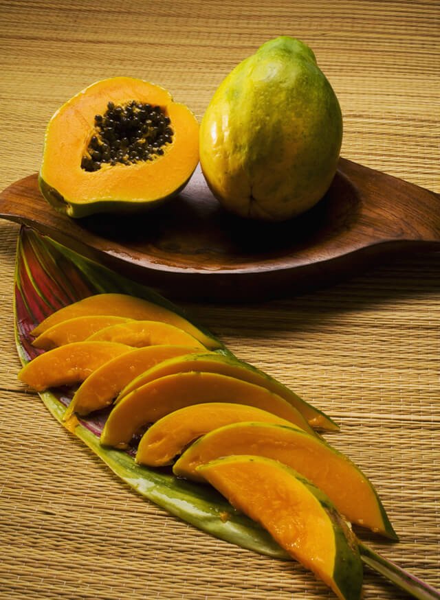 Hawaiian papaya halved and sliced on a plate