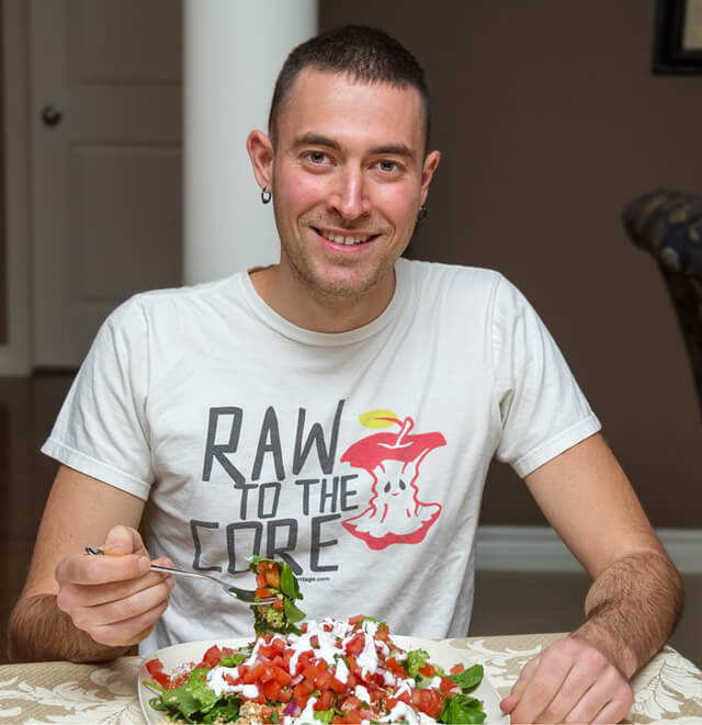 Jon Kozak eats while wearing a "Raw to the Core" T-shirt