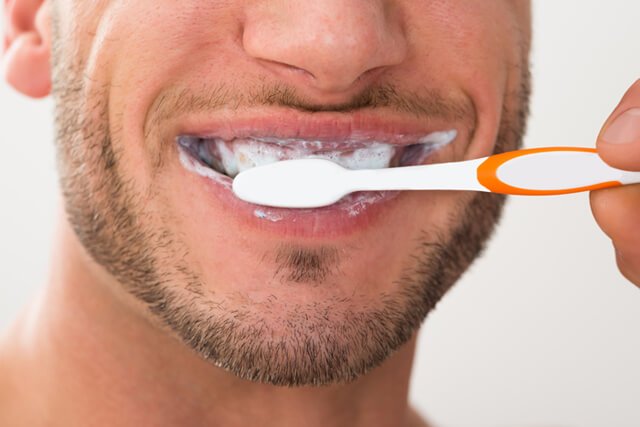 Closeup of a man brushing his teeth