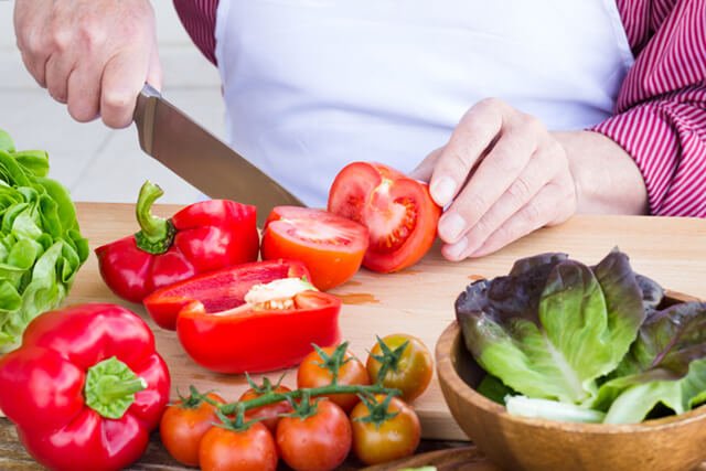 Man cutting nonsweet fruits in making a salad