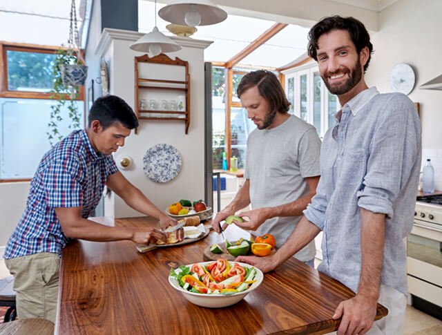 Man standing behind a salad on a table