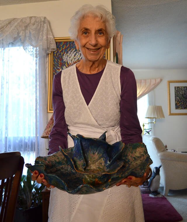 Betty Korba holds a sculpture of a sea creature