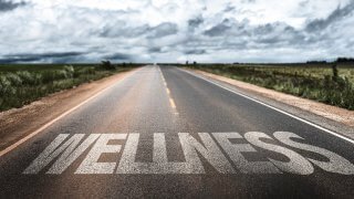 The word "wellness" written on a road