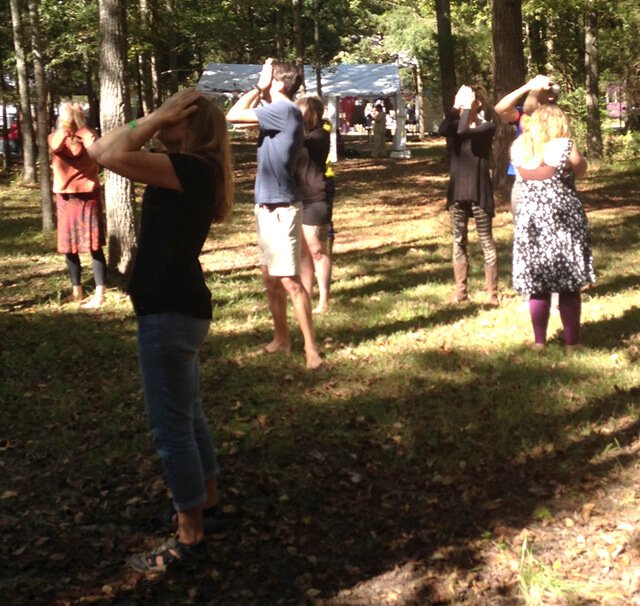 Nathan Oxenfeld leads a palming practice at the Shakori Hills Grassroots Festival in Silk Hope, North Carolina