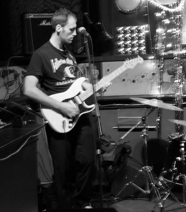 Ronnie Smith plays guitar in a black-and-white photograph