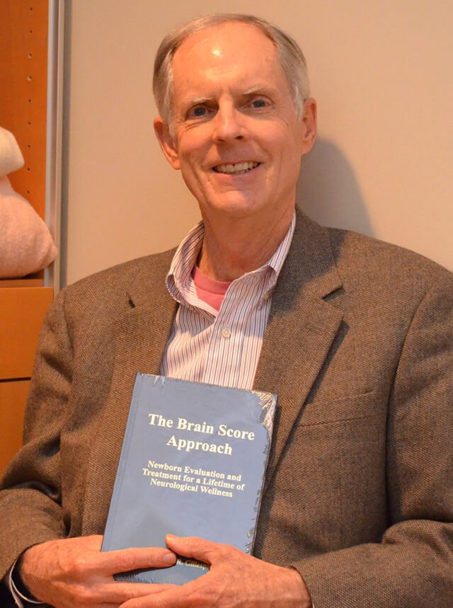 Dr. Barry Gillespie holds a copy of his book The Brain Score Approach