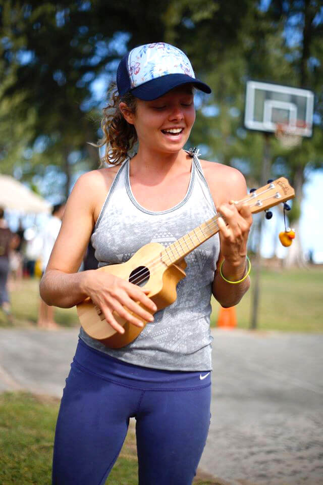 Katy Craine plays a ukulele while standing