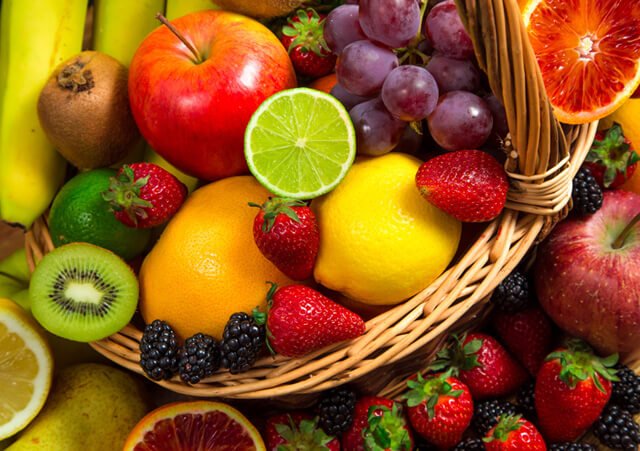A basket teems over with colorful fruits