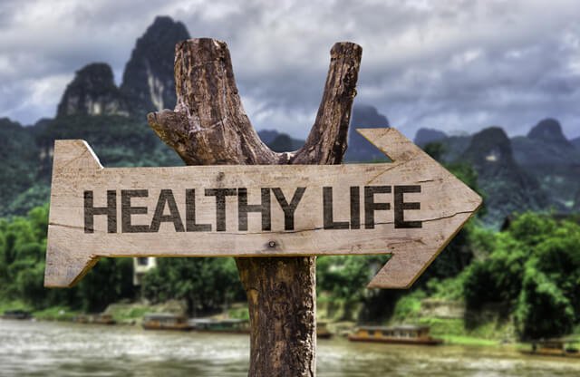 The words "healthy life" etched into a wooden sign