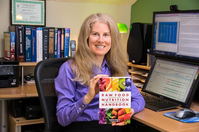 Karin Dina holds up a copy of The Raw Food Nutrition Handbook
