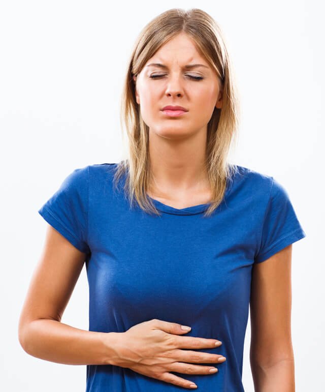 A woman with a stomachache rubs her belly