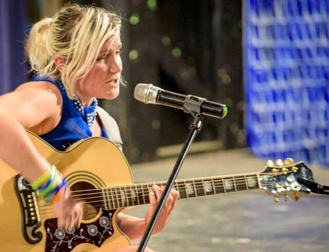 Anastasia Voss plays guitar at The Woodstock Fruit Festival