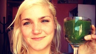 Anastasia Voss raises a green smoothie in a glass