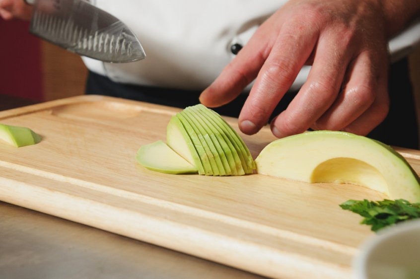 Chef cutting avocado into slices - Fruit-Powered