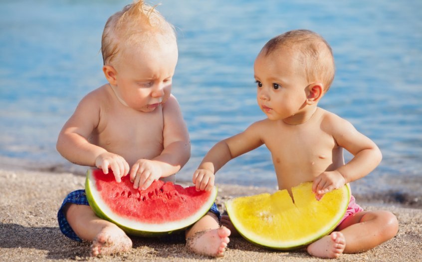 Two toddlers hold cut watermelon - food combining chart - food combining rules - Fruit-Powered