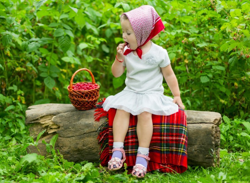 Young girl eats raspberries from a large basket - food combining chart - food combining rules - Fruit-Powered