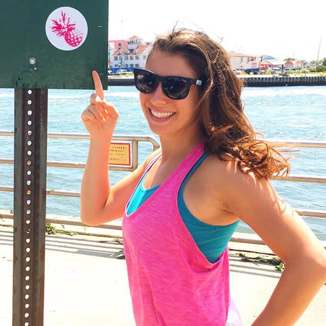 Rawthenticity's Lori Weiss points to a sign containing a pineapple sticker.