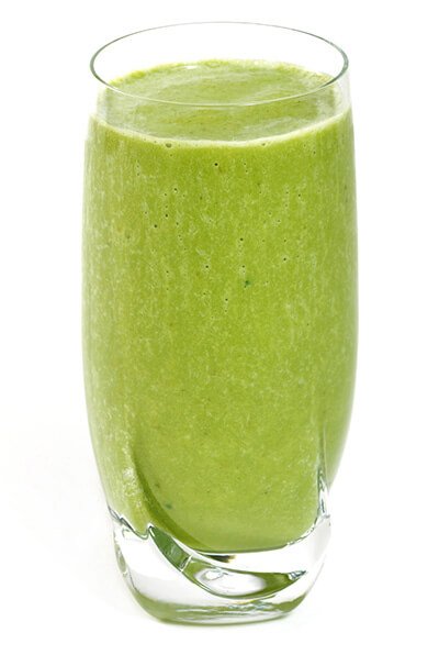A glass of green smoothie on white background