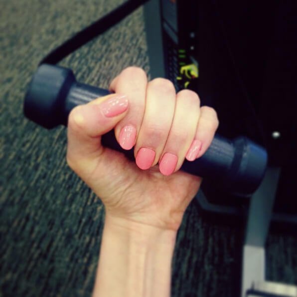 Closeup photograph of Jenny Lapan's left hand holding a dumbbell
