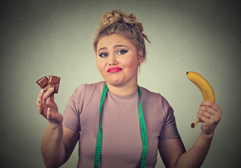 A woman holds a banana and chocolate