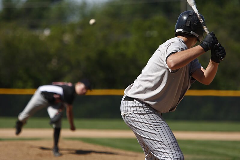 A pitcher throws a baseball to a batter