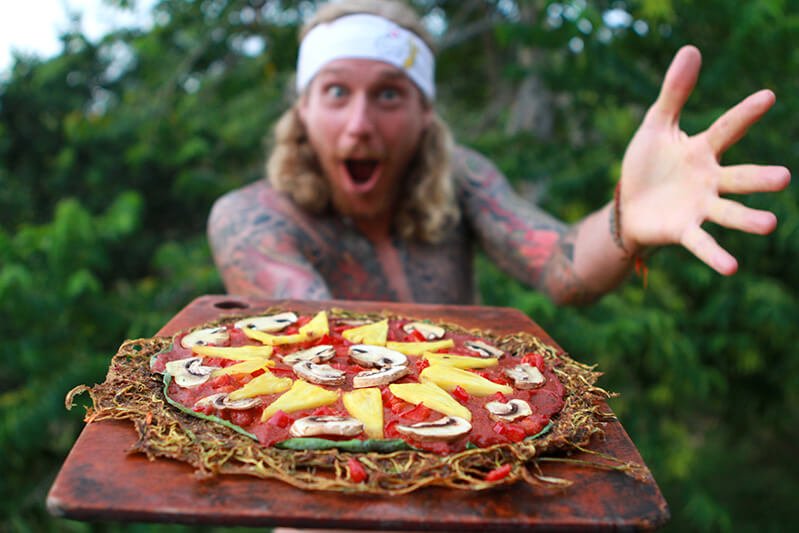 Chris Kendall holds a raw food pizza