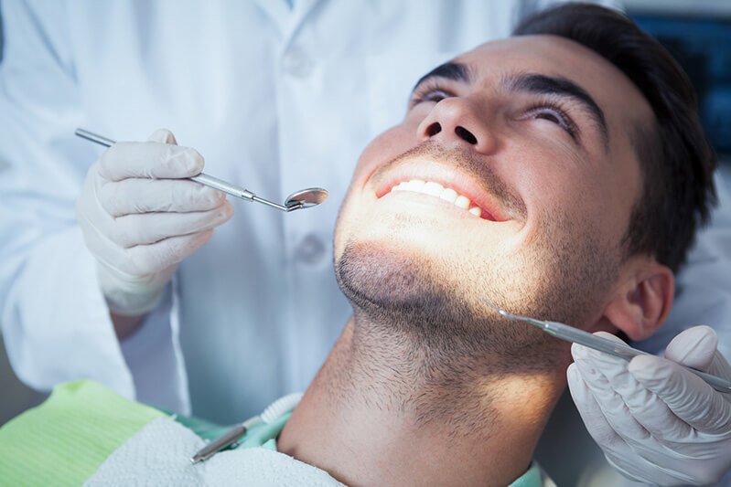 Man opens his mouth wide at a dental appointment