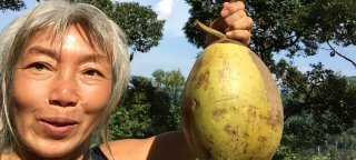 Ping Chan holds a coconut outside