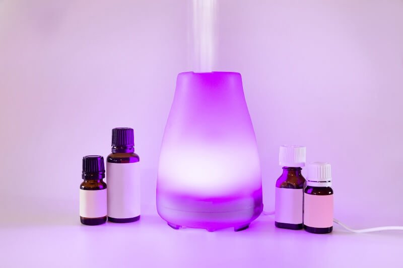 Essential oils and a diffuser lighted up purple