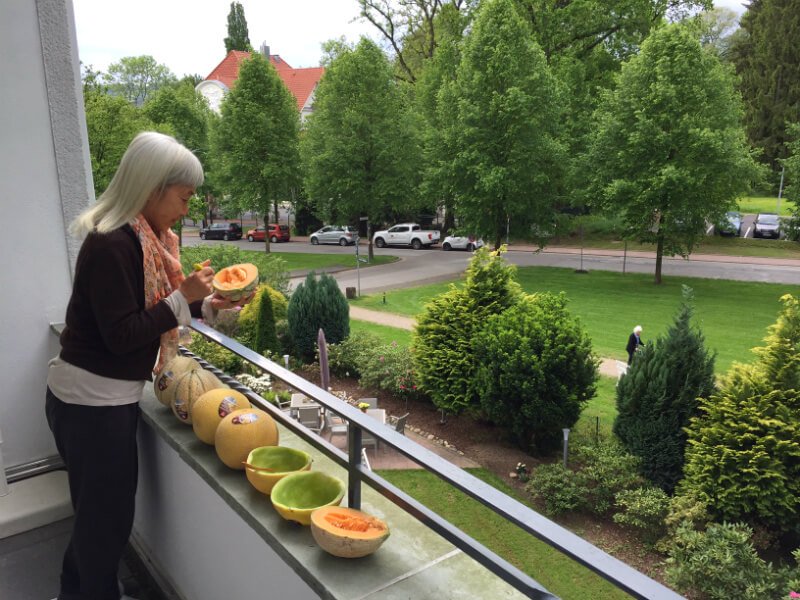 Ping Chan eats melons on a balcony in Germany