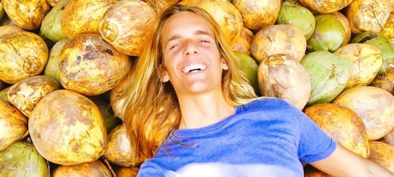 Nicolas Dudet lays on a bed of coconuts
