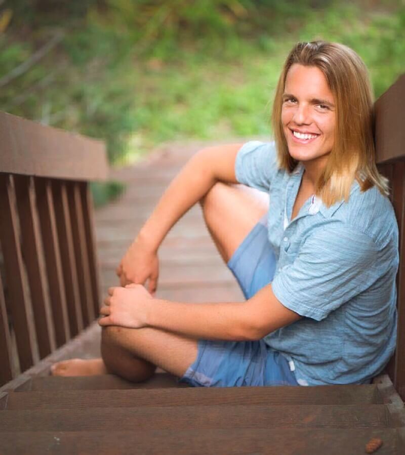 Nicolas Dudet smiles while resting on stairs